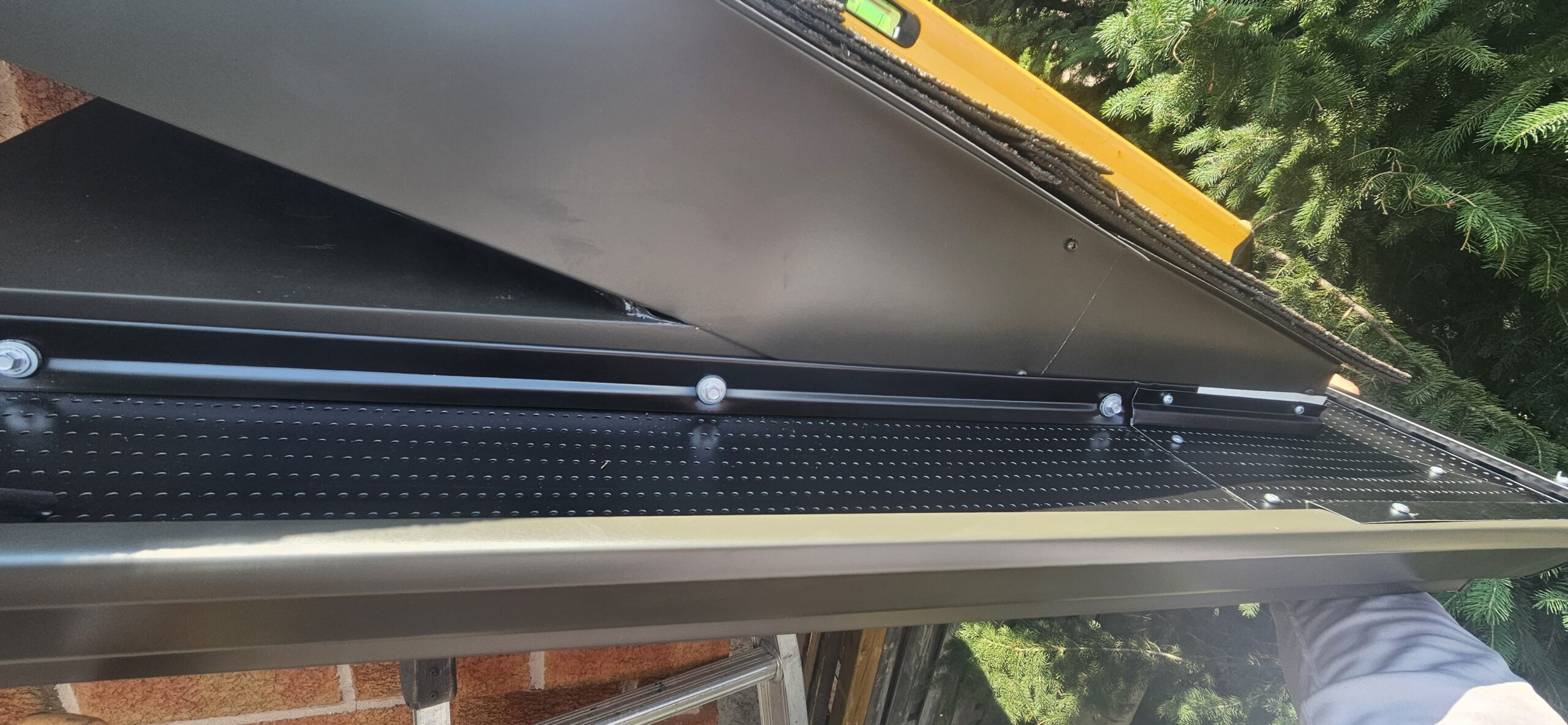 Close-up of aluminum gutter guard attached to eavestrough