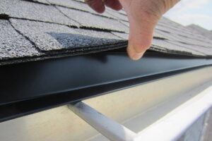 close up of drip edge under shingles directing water into gutter