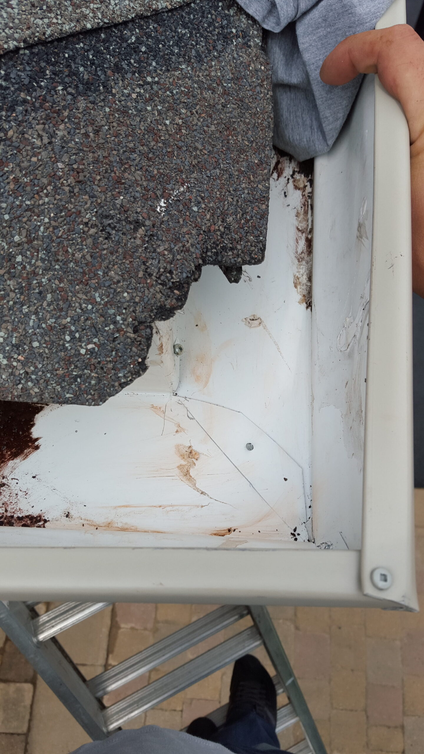 damaged eavestrough section being repaired on house exterior