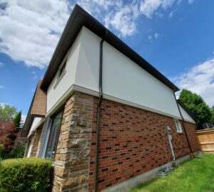 downpipe installation secured to brick and stucco wall in Scarborough