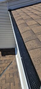 Black gutter guard installed on modern home exterior