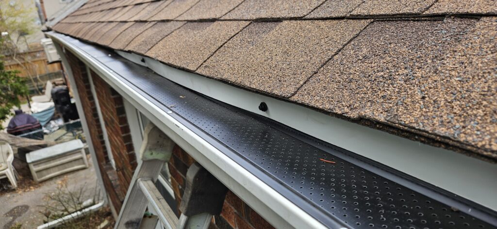 Gutter guard installation on upper roof section