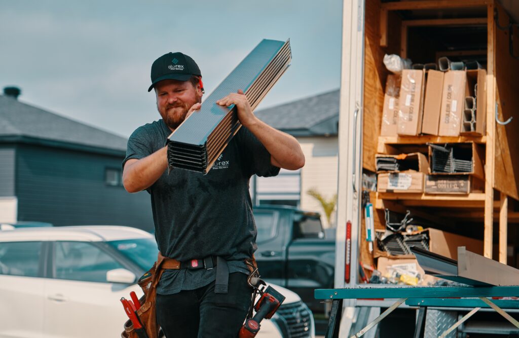 Professional installer carrying a box of material, illustrating our focus on quality products and dependable service